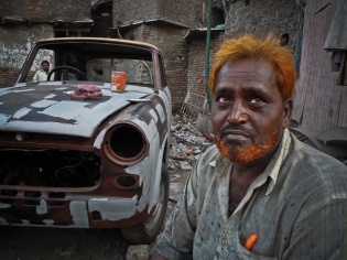  LeDesk_0040601.jpg / Sylvain Leser / Le Desk  -  Inde / Maharashtra / Bombay  -  19/05/2010  -  Regard d'Indien: Bombay.  -  ‟Orange mecanique‟. Un chauffeur ayant decide de reparer la carrosserie de son taxi; il vit dans le Bidonville de Dharavi.